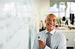 Businessman smiling at whiteboard in office