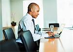 Businessman using laptop at conference table