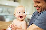 Father holding baby in kitchen