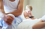 Boy using digital tablet on bed