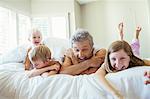 Father and children relaxing on bed