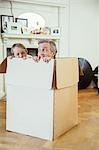 Father and son playing in cardboard box