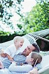 Father and children relaxing in hammock