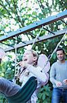Father pushing daughter on swing outdoors