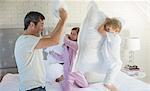 Father and children having pillow fight