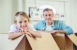 Father and son playing in cardboard boxes