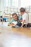 Father and son reading in bedroom