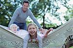 Father and children laying in hammock outdoors