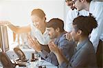 Business people cheering at computer in office