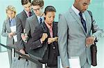 Business people checking wristwatches in waiting area