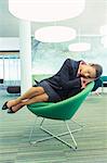 Businesswoman napping in office chair