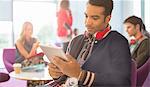 University student using digital tablet in lounge