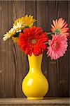 Gerbera flower on the vase, and the wooden background.