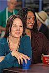 Mixed couple together in cafe with coffee mugs