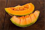 Slices of yellow melon on rustic wooden table