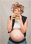 Young pregnant single female eating a sandwich