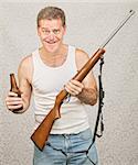 Single male hillbilly holding beer and rifle