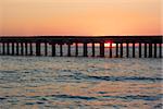 Old sea pier during the beautiful sunset over the sea coas