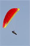 A paraglider falling from the sky with his parachute