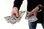 Person holding several new hundred dollar bills shot on white background.  This newly redesigned US currency was released for circulation in October of 2013.