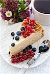 Piece of homemade honey cake decorated with fresh blueberries and red currants