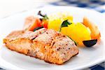 Salmon with oranges, tomatoes and olives on a plate