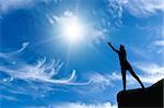 woman on a mountain top his arms in hand against the sunny sky