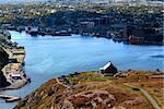 Cannons and building of Queen?s Artillery Battery on Signal Hill, St. John?s Newfoundland. Battery is built to protect ?The Narrows? approach to Harbor seen on background in sunny with clouds day.