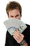 A young handsome man holding a lot of new hundred dollar bills isolated on white background.  He is staring at the money with a look of disbelief.  This newly redesigned US currency was released for circulation in October of 2013.