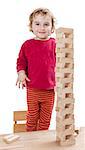 child with tower made of  toy blocks. studio shot isolated on white background