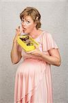 Guilty pregnant woman pigging out on box of chocolates