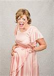 Anxious pregnant woman in pink dress on gray background