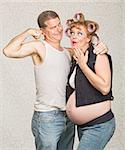 Amazed pregnant hillbilly woman and man flexing biceps