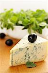 a large piece of blue cheese and black olives