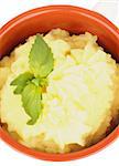 Classical Mashed Potato in Bowl Garnished with Green Basil Leafs. Top View