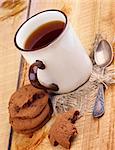 Rustic Cup of Black Tea with Chocolate Chip Cookies and Tea Spoon closeup on Wooden background