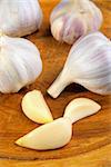 garlic cloves and buds on a wooden plate