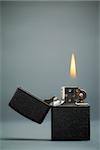 black gasoline lighter with flame on dark background