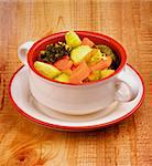 Homemade Rustic Vegetable Stew with Carrot, Broccoli, Potato and Leek in Bowl with isolated on Wooden background