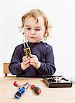child choosing tool for repairing hard drive. Studio shot in gery background