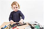 child repairing computer part. studio shot in light grey background