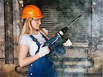 beautiful blond woman with heavy drill in his hand