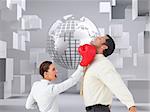 Composite image of businesswoman hitting a businessman with boxing gloves on white background