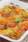 Colorful tomatoes with mozzarella and pesto on baking sheet