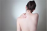 Rear view of a young woman touching her back