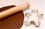 Gingerbread dough, wooden rolling pin and gingerbread man cookie cutter