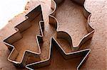 Closeup of festive cookie cutters on gingerbread dough
