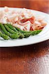 Green asparagus and prosciutto on a plate