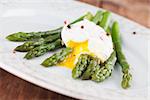 Green asparagus with poached egg on a plate