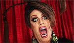Screaming man in drag over red curtain